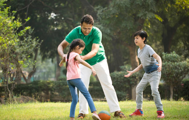 istock Family playing with ball at park 1193914084