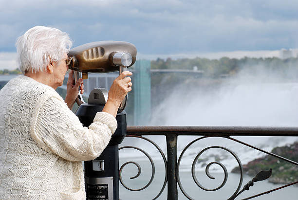 istock senior tourist using binoculars at niagara falls 119391617