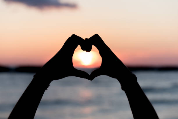 istock Heart with hands at dawn 1193918858