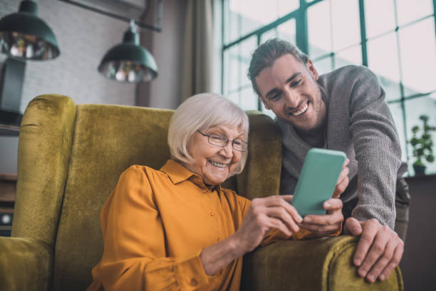 istock Elderly lady in yellow learning how to use smartphone 1193919066