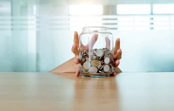 istock Woman hand holding a coins jar 1193919097