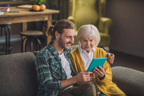 istock Grey-haired elderly woman looking at the tablet 1193919122