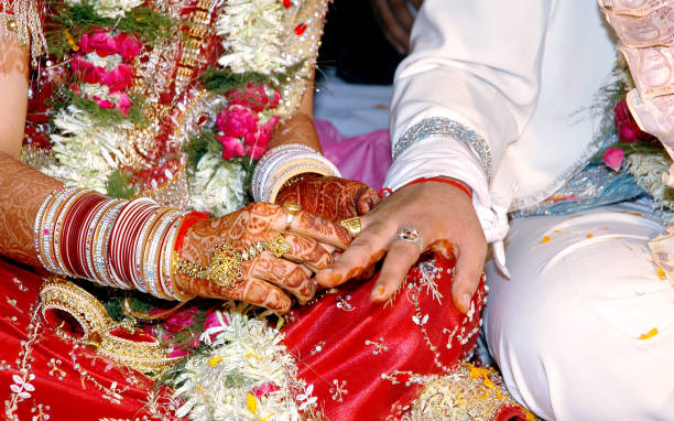 istock Indian Bride putting a wedding ring on groom's finger 1193922624