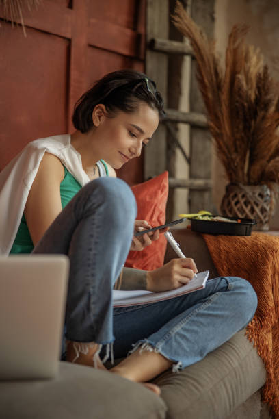 istock Smiling woman is using smartphone at home 1193923876