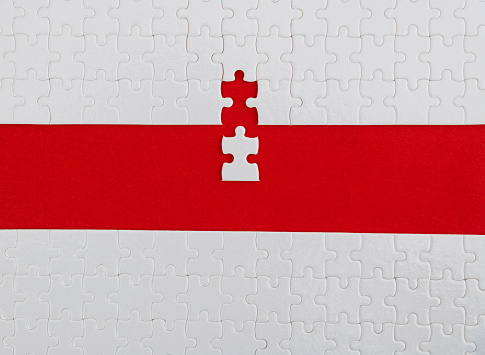 White jigsaw puzzle on red background.
