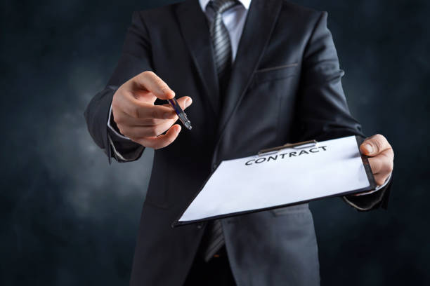 Businessmans hand holding a pen requesting a signature on a contract Businessmans hand holding a pen requesting a signature on a contract assertiveness stock pictures, royalty-free photos & images