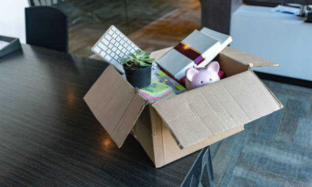 Moving office and packing belongings in a box Moving office and packing belongings in a box or getting fired belongings photos stock pictures, royalty-free photos & images