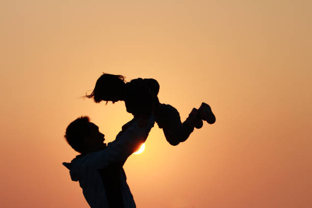 silhouette of father and daughter silhouette of father and daughter under sunset. background for father's day and happy family. baby gun stock pictures, royalty-free photos & images
