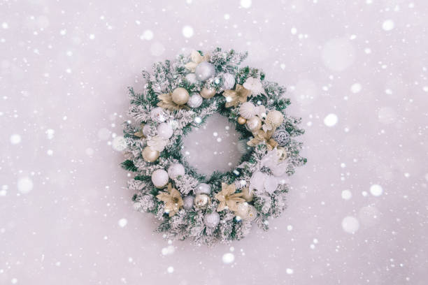 istock Snowy christmas wreath on a white wall with place for text, close up 1193929342