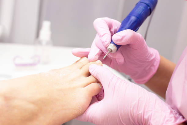 istock Professional hardware pedicure using an electric machine. Patient at the pedicure procedure. polishing the nail plate, processing the cuticle using a pedicure machine. 1193929476