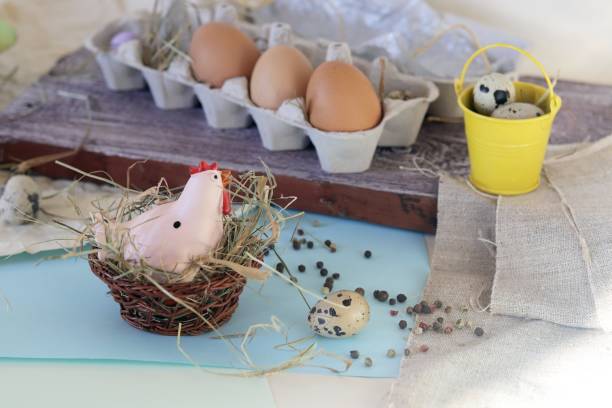 istock Toy chicken, eggs, hay, Easter decor on a light background 1193929560