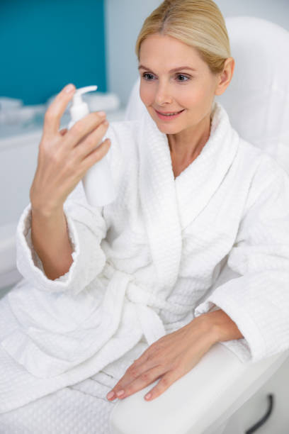 istock Pretty woman looking on cream in hand 1193929572