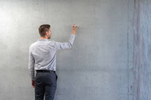 Business man at the office writing on the wall
