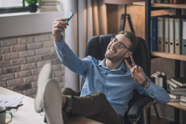 istock Young bearded man in eyeglasses having videocall 1193930267