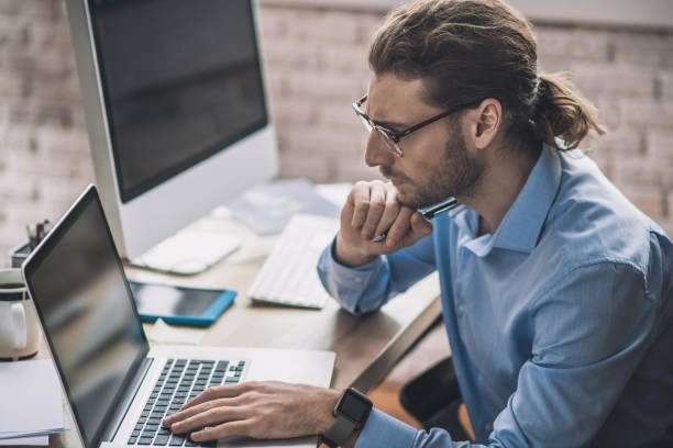 istock Young bearded office worker looking concentrated and thoughtful 1193930286