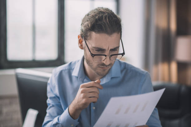 istock Young bearded man in blue shirt looking concentrated 1193930379
