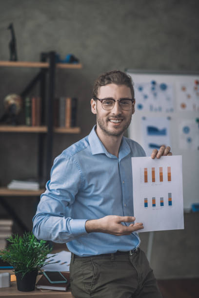 istock Young bearded man in blue shirt showing a draft 1193930414