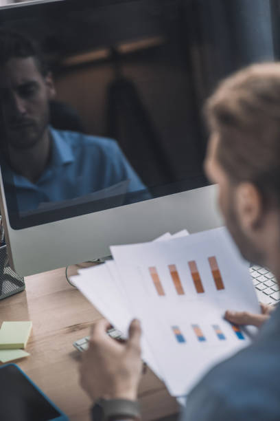 istock Young bearded man in blue shirt working with schemes 1193930439