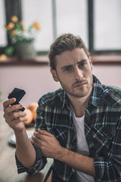 istock Disappointed handsome man holding a wedding ring box 1193930519