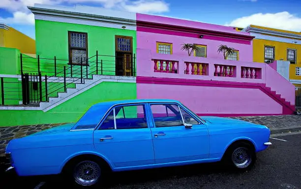 Residential homes in the Bo-Kaap neighborhood, painted in a variety of bright colors, such as vivid pink, lime green, lemon yellow. Cape Town, South Africa