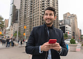 Happy man in New York texting on his cell phone