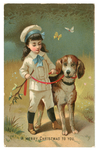 A cute Victorian Christmas card showing a young boy wearing a knickerbocker suit out walking with his dog. Butterflies flutter past on a sunny day - obviously not in December! The dog is wearing a red lead which is decorated with bells.