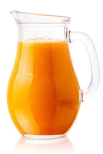 Pumpkin or butternut squash smoothie or freshly pressed juice in a pitcher, isolated