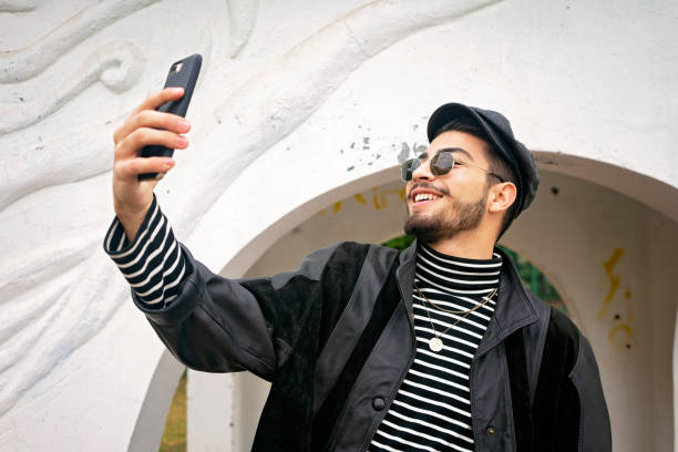 istock Young man in leather jacket taking selfie with mobile phone. 1193935055