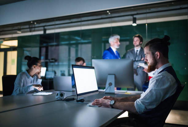 istock A group of business people in an office at night, using computer. 1193951261