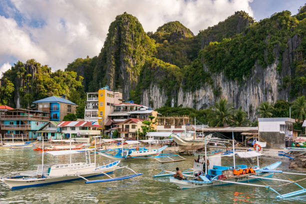 Tourist and fishing boats off the coast of El Nido town El Nido Palawan, Philippines - December 6, 2017: Tourist and fishing boats off the coast of El Nido town boracay photos stock pictures, royalty-free photos & images