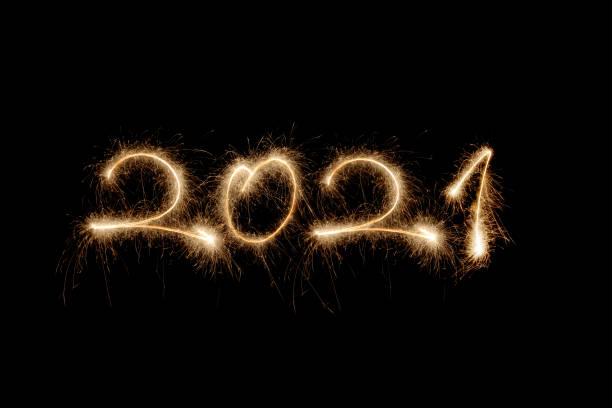 new year 2021 sparklers 2021 written with sparklers in the black sky. firework display pyrotechnics celebration excitement stock pictures, royalty-free photos & images