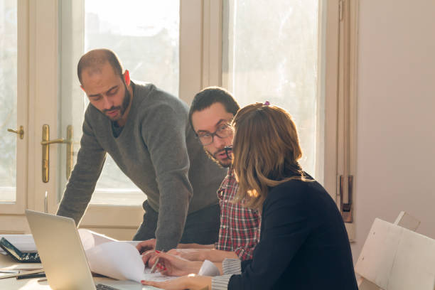 istock Group of young architects in the sunny office. 1193951482