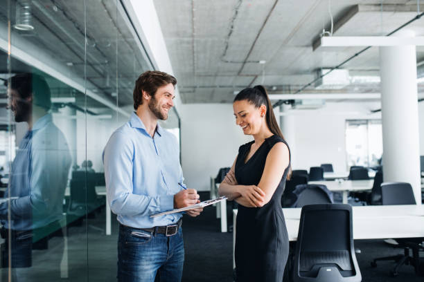 istock Young businesspeople with clipboard in an office, working. 1193951489