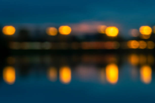Blurred image for background. Night traffic and lanterns lights with reflection in water.