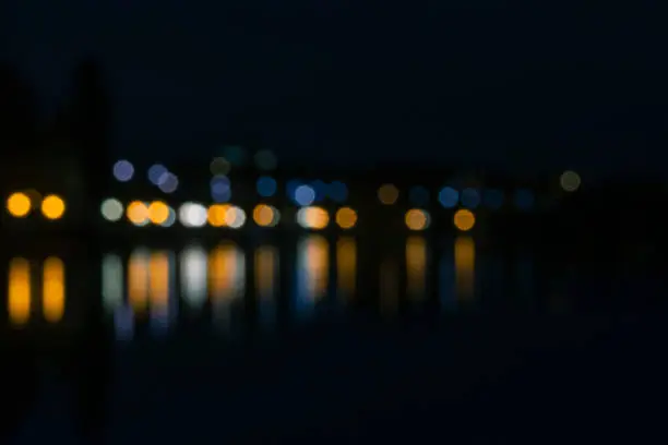 City lantern lights reflection in water. Black background image, city nightlife concept.