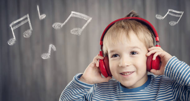 niño sobre fondo de madera con auriculares rojos - headphones party little boys dancing fotografías e imágenes de stock