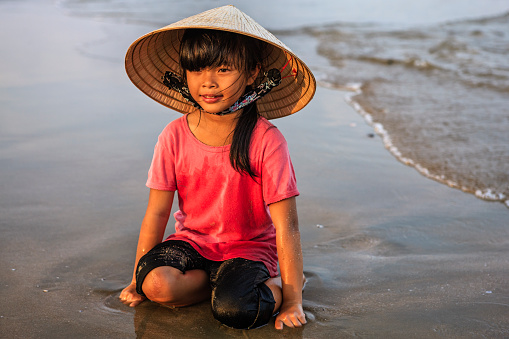Portrait of Vietnamese little girl standing on the beach, Vietnam