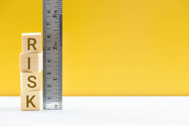 Risk assessment / risk analysis and management concept : Words RISK on wood blocks and a vertical ruler with scales, depict evaluation for financial risk of an investor involved in stock, bond market evaluación de riesgos / análisis de riesgos y concepto de gestión : palabras risk en bloques de madera y una regla vertical con escalas, representan la evaluación del riesgo financiero de un inversor involucrado en acciones, mercado de bonos