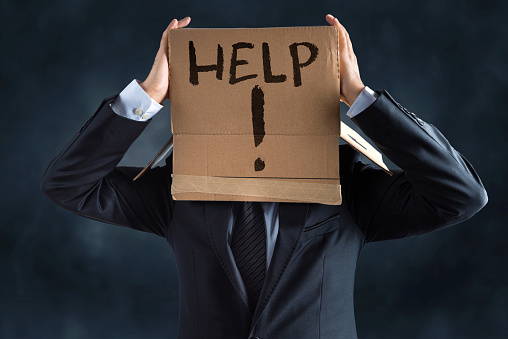 Businessman with cardboard box over his head ask for help