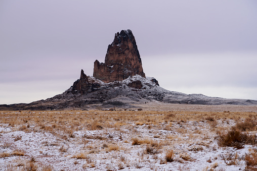 Agathla Peak (Navajo: Aghaałą́, Spanish: El Capitan) is a peak south of Monument Valley, Arizona, which rises over 1500 feet (457 meters) above the surrounding terrain. It is 7 miles (11 km) north of Kayenta and is visible from U.S. Route 163.