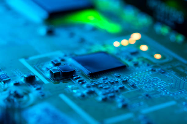 istock Electronic circuit board close up with green backlight and a light haze 1193958593