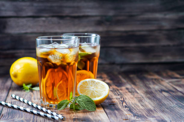istock Iced tea with lemon and ice on a wooden background 1193959738