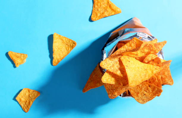 doritos de jetons de sac sur le fond bleu - cheese sauce cheese tortilla chip nachos photos et images de collection