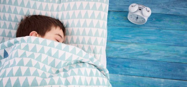 istock eight years old child sleeping in bed on pillow 1193960564