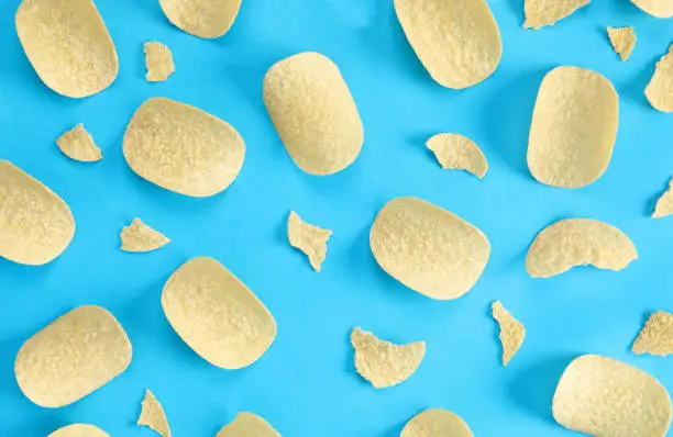 Photo of pattern potato chips on blue background