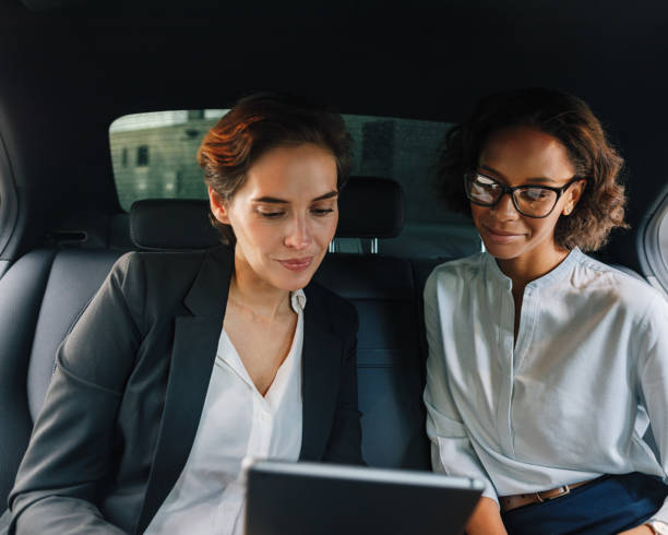 istock Two business people using digital tablet in taxi 1193963322