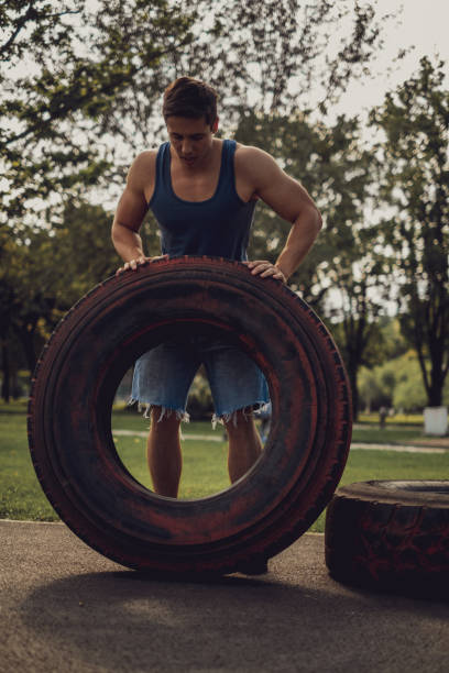 istock Athletic man flipping tire in the park 1193964285