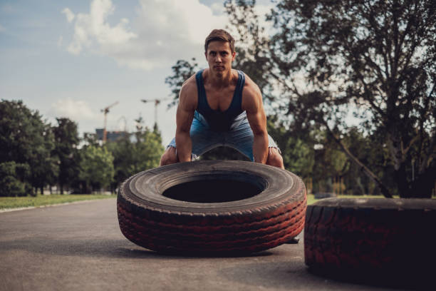 istock Athletic man flipping tire in the park 1193964302