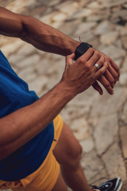 istock Man holding smartwatch outdoors 1193964306