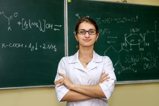 istock Chemical education. Woman near board explaining to students some material 1193968462